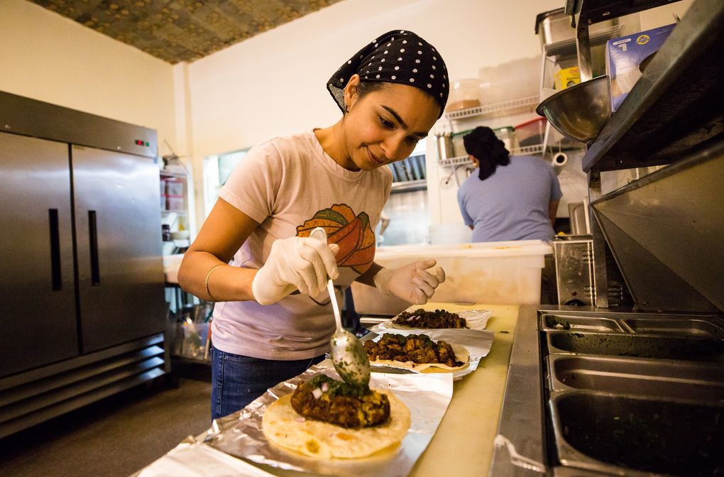 Spice Waala co-owner Aakanksha Sinha tops kathi rolls with the absurdly good house-made cilantro-and-mint chutney. (Rebekah Welch / The Seattle Times)