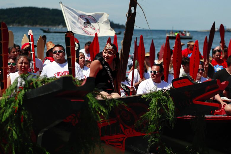 Princess Jayla Moon, 12, center, of the Port Gamble S’Klallam Tribe, listens as tribal canoes request permission to come ashore at the Lummi Nation Stommish Grounds last month. Thirty years ago in the same canoe, Jayla’s mother, Mandi Moon, rode on the bow as the princess and while her grandfather served as the skipper during the Paddle to Seattle. “I am super proud of her,” says Mandi Moon, the Port Gamble S’Klallam Tribe’s first princess, about her daughter. “We take a lot of pride in our culture …There are no words seeing her coming in with her crown on … It was just amazing. I know my grandfather would have been smiling big down on her.” (Erika Schultz / The Seattle Times)
