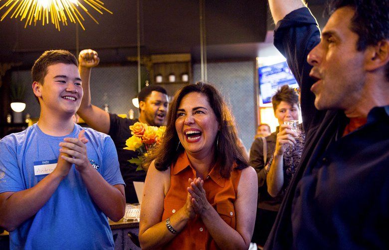 Tammy Morales celebrates her lead in the primary at her election watch party at Bang Bang Kitchen, as her husband Harry Teicher (right) holds up the results on his phone on Tuesday, August 6. Morales is running for Seattle City Council District 2. 211109 211109