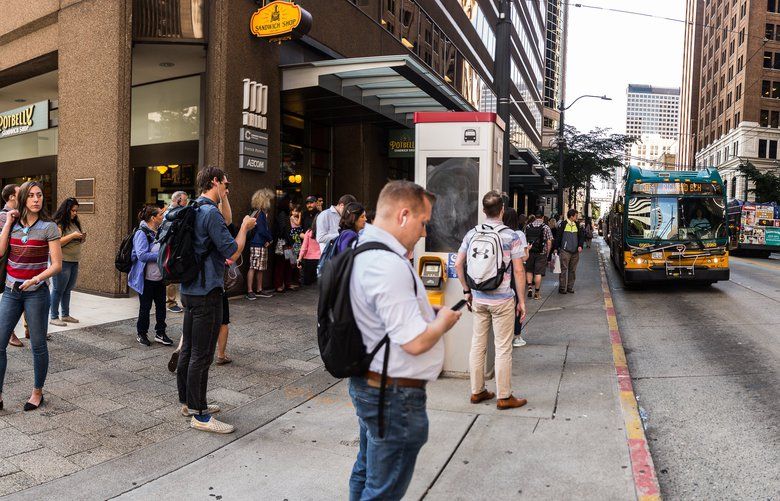Commuters going south crowd around a bus stop on 3rd Ave in downtown Seattle on Monday, August 12. 211160
