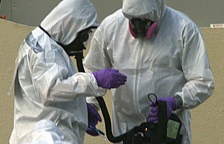 A FBI special response team investigator, left, has his bio-hazard equipment removed by a support crew at American Media Inc., in Boca Raton, Fla., Saturday, Oct. 13, 2001. (AP Photo/Luis M. Alvarez)

FLA104