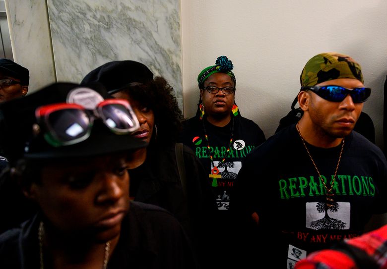 Activists stand in line waiting to enter a hearing about reparation for the descendants of slaves, before the House Judiciary Subcommittee on the Constitution, Civil Rights and Civil Liberties, at the Capitol on June 19, 2019 in Washington, D.C.