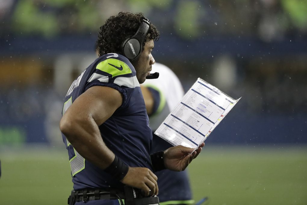 Seattle Seahawks quarterback Russell Wilson holds a play sheet as he stands on the sideline during the first half of an NFL football preseason game against the Oakland Raiders, Thursday, Aug. 29, 2019, in Seattle. (Elaine Thompson / The Associated Press)
