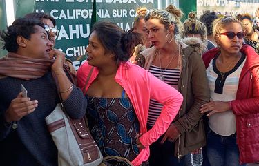 Dozens of transgender women and gay men traveling with the Central American migrant caravan wait in line to receive a number as part of the process to apply for asylum in the United States, at the border in Tijuana, Mexico, Thursday, Nov. 15, 2018. Arriving ahead of the bulk of the Central American migrant caravan, dozens of transgender women and gay men added their names to a book and were given numbers Thursday, with the hope of requesting asylum in the U.S. (AP Photo/Gregory Bull)