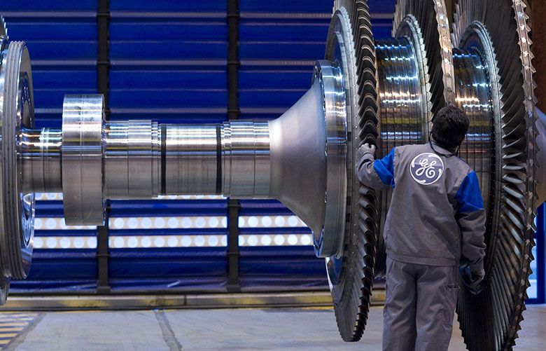 A General Electric Co. employee examines a component for a gas turbine. (Fabrice Dimier / Bloomberg) 
GE
