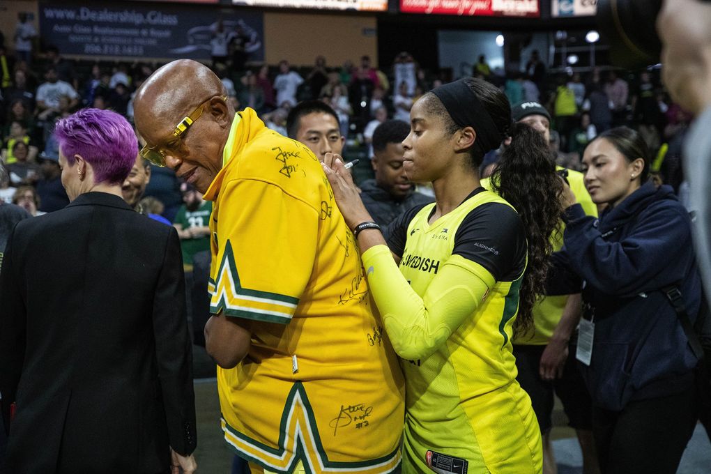 Jordin Canada signs the back of Sonics legend Slick Watts’ shirt after her career game Wednesday against Minnesota in the WNBA playoffs. (Dean Rutz / The Seattle Times)