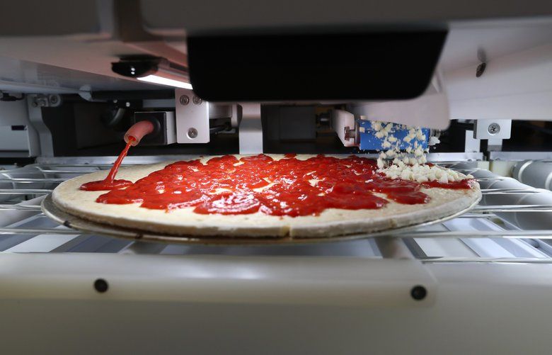 EMBARGO UNTIL OCT. 1 — A cheese pizza is made during a demonstration of an automated assembly platform designed for hospitality industries, at Seattle-based Picnic, Wednesday, Sept. 25, 2019 in Seattle. The 16-inch pizza took a little over a minute to come out, and was then run through an industrial conveyor oven. 211557