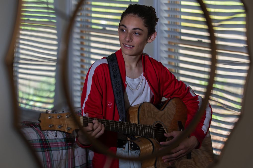Benicio Bryant, a Maple Valley teen who’s on “America’s Got Talent,” strums the guitar in the home he shares with his sister and parents. (Ellen M. Banner / The Seattle Times)