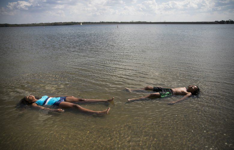Caira Jackson, 9, left, and Cain Christensen, 11, relax in Alum Creek Lake in Lewis Center, Ohio, on Monday, Oct. 1, 2019. Officials in Columbus closed the city’s schools because of the oppressive heat and humidity. (Maddie McGarvery, The New York Times) XNYT249