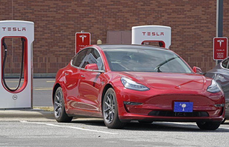 FILE – This Friday, July 19, 2019, file photo shows a Tesla vehicle charging at a Tesla Supercharger site in Charlotte, N.C. Teslaâ€™s electric car sales accelerated again during the summer, but the company is still lagging behind the pace it needs to reach CEO Elon Muskâ€™s goal for the entire year. (AP Photo/Chuck Burton, File) 1