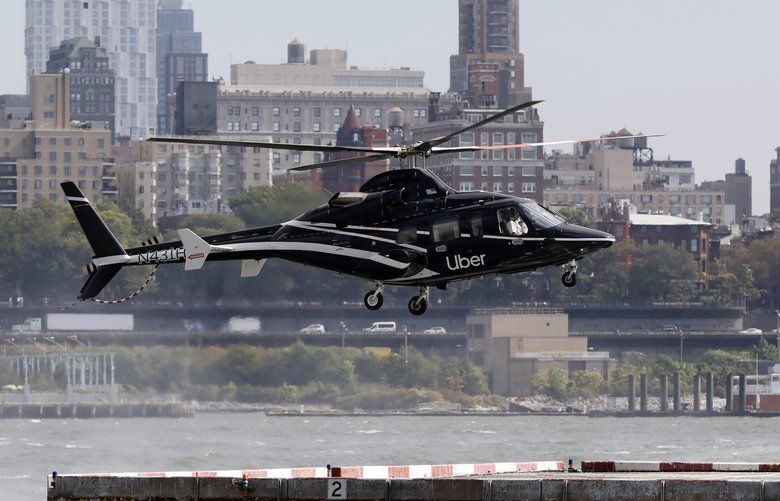 In this Wednesday, Oct. 2, 2019, photo an Uber helicopter lands at the Downtown Manhattan Heliport, in New York. The ride-hailing company expanded its helicopter service Thursday, Oct. 3, between lower Manhattan in New York City and John F. Kennedy International Airport, making it available to all Uber riders with iPhones instead of just those in the top tiers of its rewards program. (AP Photo/Richard Drew) NYRD202 NYRD202