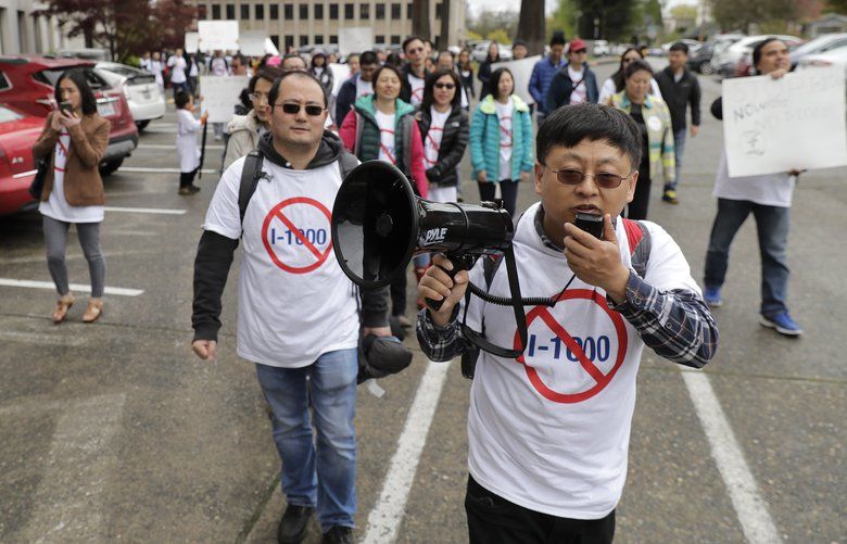 Protesters opposed to Initiative 1000 chant and march following a joint Washington state House and Senate committee, Thursday, April 18, 2019, at the Capitol in Olympia, Wash. Several members of the group spoke in opposition to Initiative 1000, which would allow the state government to use affirmative action policies that do not constitute preferential treatment to remedy discrimination in public employment, education and contracting. (AP Photo/Ted S. Warren) WATW114