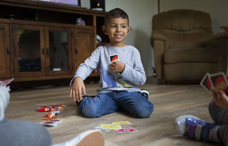 Tiago Viernes, 5, plays Uno with his neighbors before dinner with his family on Wednesday, Oct. 2, 2019 in Wapato, Wash.