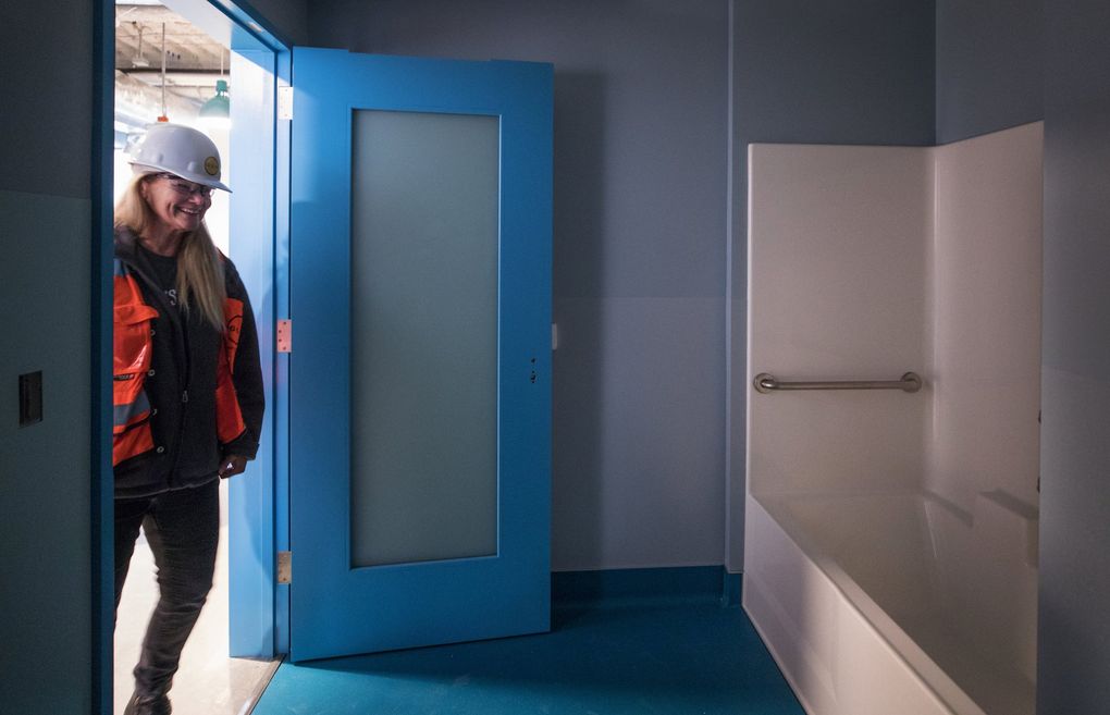 Mary’s Place Executive Director Marty Hartman smiles at seeing a bathtub in the new shelter built into an Amazon office building. None of her organization’s other shelters have this amenity. (Steve Ringman / The Seattle Times)