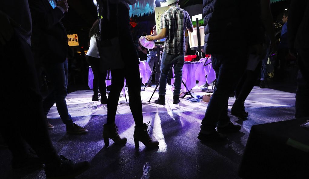 With the feeling of a nightclub, Art Battle Seattle begins a 20-minute round of competition. Each canvas is the same size and acrylic paint is provided. Audience members walk in a counterclockwise circle around the artists as they work. (Alan Berner / Seattle Times)