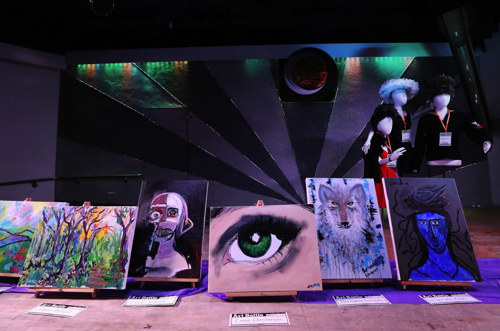 Completed paintings from the first round of competition during September’s Art Battle Seattle are placed on stage at Eden Seattle in Sodo. (Alan Berner / Seattle Times)