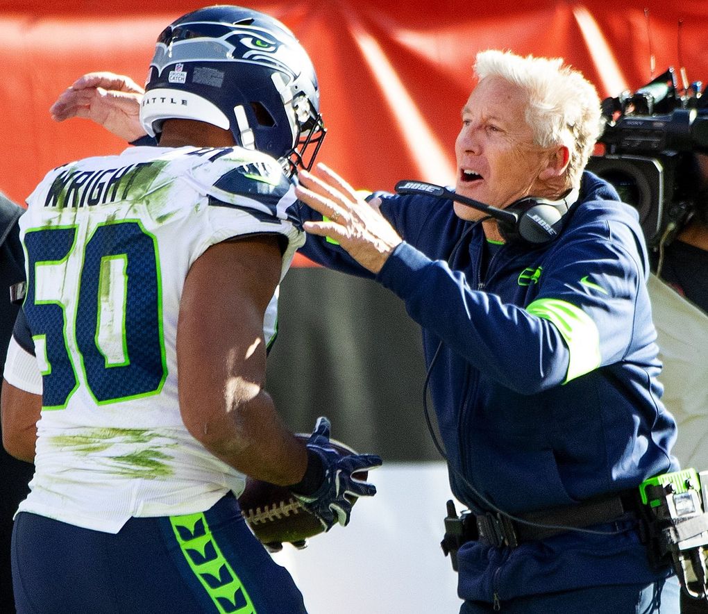 Seahawks head coach Pete Carroll embraces outside linebacker K.J. Wright after Wright intercepted Browns quarterback Baker Mayfield, sealing the Seattle victory Sunday in Cleveland. (Mike Siegel / The Seattle Times)