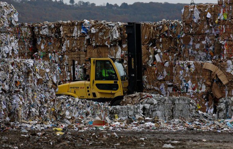 A forklift truck driver moves bales of recycled cardboard at a paper mill in the U.K. The paper recycling industry, it turns out, has suddenly found itself in demand-and maybe just in the nick of time.