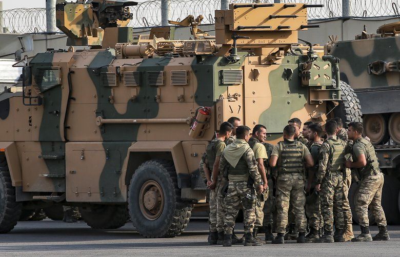 Turkish soldiers prepare to enter Syria aboard an armoured personnel carrier at the border with Syria in Karkamis, Gaziantep province, southeastern Turkey, Tuesday, Oct. 15, 2019. Turkey defied growing condemnation from its NATO allies to press ahead with its invasion of northern Syria on Tuesday, shelling suspected Kurdish positions near the border amid reports that Syrian Kurds had retaken a key town. (AP Photo/Emrah Gurel) XLP109 XLP109