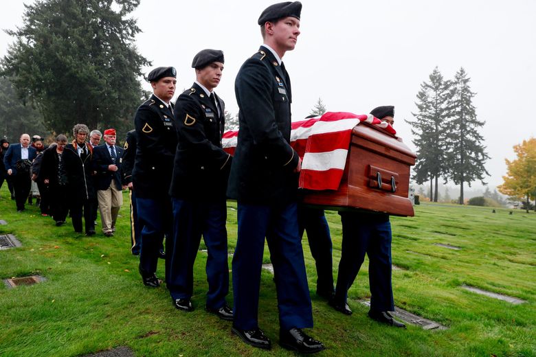 A military funeral honors team carries the casket of Army Pfc. Donald E. Mangan during a military funeral in Gig Harbor Tuesday. Mangan was killed in Europe in 1944 and buried there. The family of Mangan walks behind, including Julia Mangan and her husband Jim Mangan, a Marine Corps veteran, seen in front. (Erika Schultz / The Seattle Times)