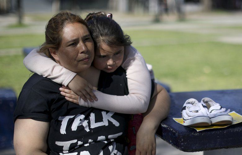 In this Oct. 8, 2019 photo, Vanesa Rivarola waits with her daughter Milena in a public park to exchange a pair of her daughter’s used shoes for two packs of flour as part of an agreement they worked out online with a stranger on the outskirts of Buenos Aires, Argentina. Three years ago, the 40-year-old mother of two left her job at a shoe manufacturer to take care of her children and sick mother, unable to afford to pay someone to look after them. Today, her contacts have turned into a large online community who barter clothing for food among themselves. “The poor help the poor, because those on top, forget it,†says Rivarola, adding “Those on top don’t see it.†(AP Photo/Natacha Pisarenko) NAT508 NAT508