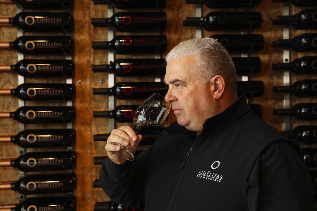 Winemaker Charlie Hoppes noses his 2016 Quintessence cabernet sauvignon at his Fidélitas tasting room. (Ken Lambert / The Seattle Times)