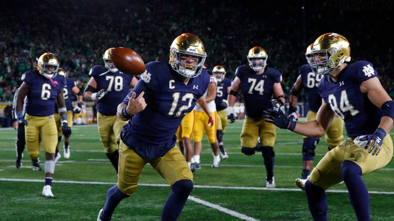 Notre Dame quarterback Ian Book and Liam Eichenberg celebrate a