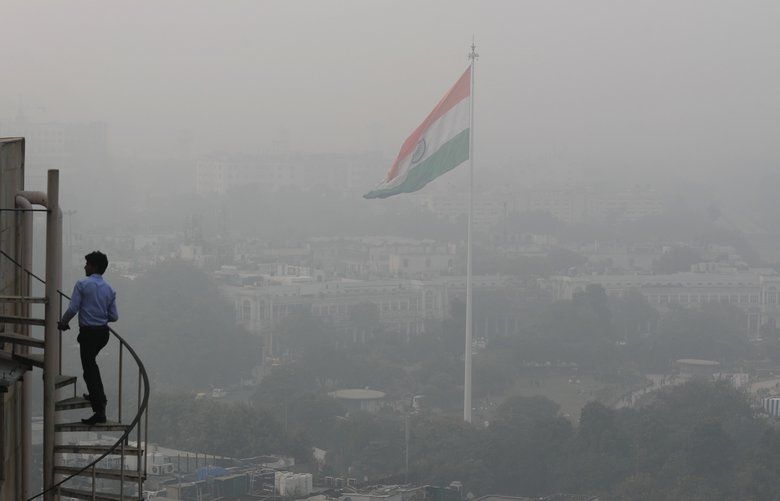 An Indian walks up to the stairs as Delhi’s sky line is seen enveloped in smog and dust in New Delhi, India, Friday, Nov. 1, 2019. An expert panel in India’s capital has declared a health emergency due to air pollution choking the city, with authorities ordering schools closed until Nov. 5. (AP Photo/Manish Swarup) XMS124 XMS124