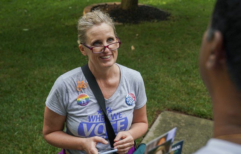 In this Wednesday, July 17, 2019 photo, Juli Briskman, the Democratic nominee for Supervisor of Loudoun County’s Algonkian District, chats with Hari Moosani as she campaigns door-to-door in her neighborhood in Sterling, Va. Briskman, who lost her job after displaying her middle finger at President Donald Trump’s motorcade, has won a seat on the Loudoun County board of supervisors in Virginia. With 99 percent of the vote reported by the Loudoun County Office of Elections Tuesday night, Nov. 5 unofficial returns showed Briskman ahead of Republican incumbent Suzanne Volpe with 52% of the vote. (Jahi Chikwendiu/The Washington Post via AP) DCWAP601 DCWAP601