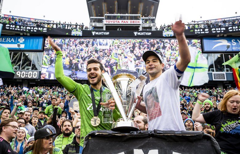 Sounders midfielder Victor Rodriguez and midfielder Nicolas Lodeiro celebrate with the Emerald City Supporters after the Seattle Sounders FC defeated Toronto FC 3-1 to win the MLS Cup Final at CenturyLink Field in Seattle Sunday November 10, 2019.  212052