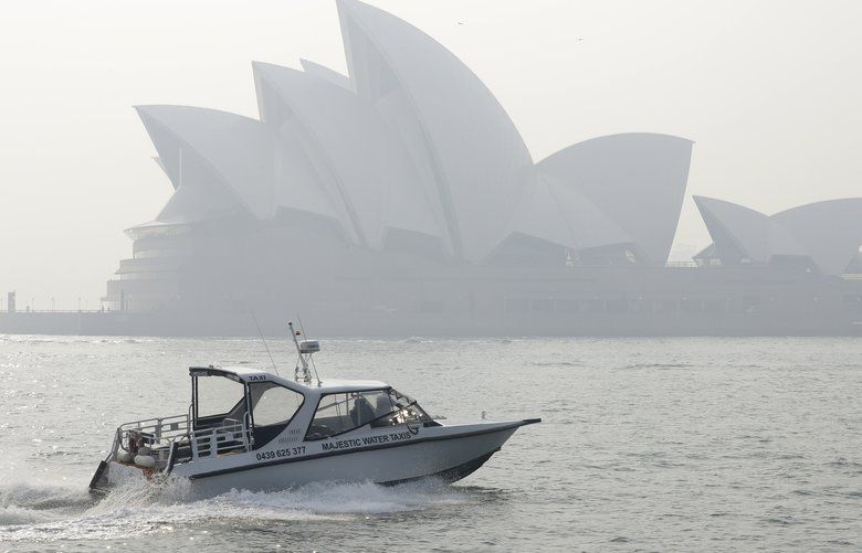 A water taxis drives by as smoke haze hangs over the Sydney Opera House in Sydney, Thursday, Nov. 21, 2019. The annual Australian fire season, which peaks during the Southern Hemisphere summer, has started early after an unusually warm and dry winter. (AP Photo/Rick Rycroft) XRR103 XRR103