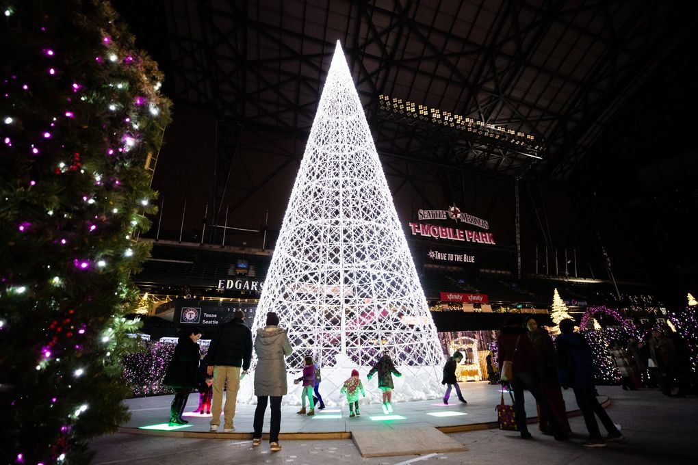 Kids leap around on light-up floor panels at Enchant Christmas. The maze, holiday market and more lights up T-Mobile Park from Nov. 22 to Dec. 29. (Andy Bao / The Seattle Times)