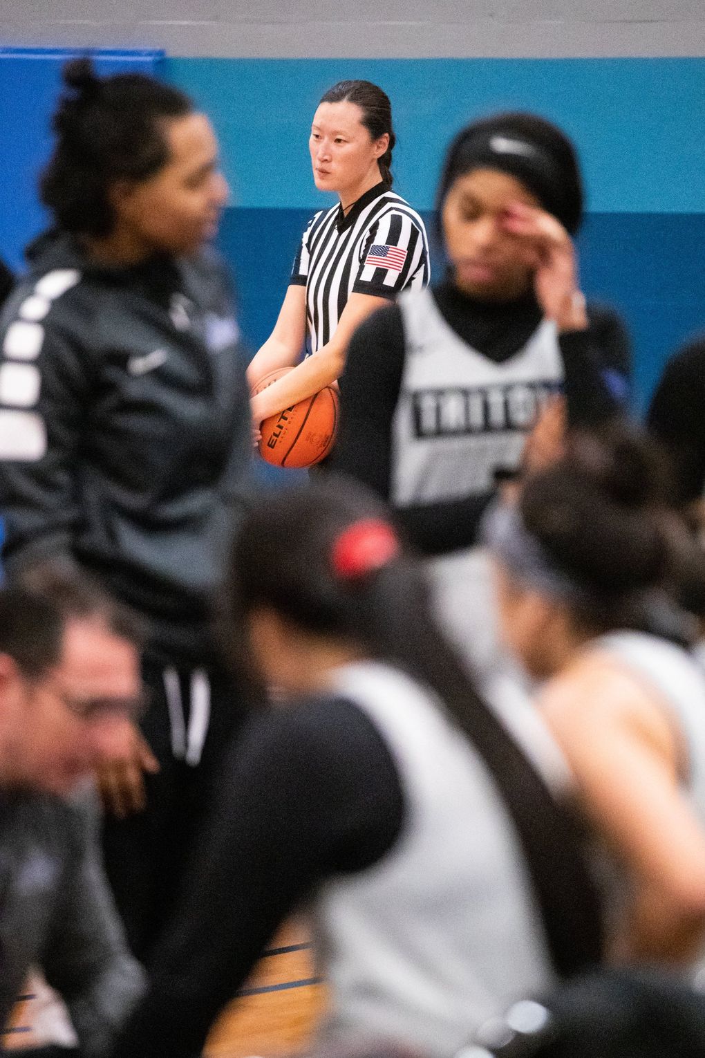 Referee Jillian Quinn waits during a timeout in a women’s basketball scrimmage. The pool of referees is shrinking while organizations struggle to bring aboard new officials. “There’s just more open games than officials,” Quinn said. “If you were a kid and you could make $20 an hour reffing a basketball game but were getting verbally abused, why would you want to do that?”
(Andy Bao / The Seattle Times)