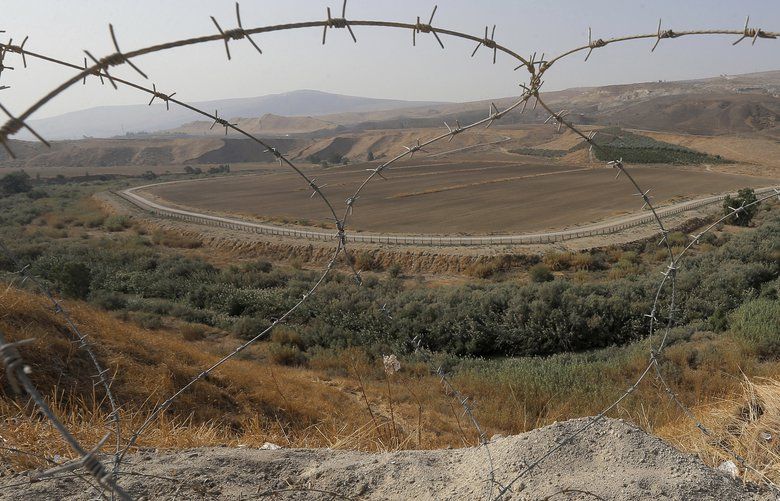 A portion of the Israeli-Jordanian border â€‹â€‹is viewed through a barbed wire fence from Baqoura, in the Jordan Valley, Wednesday, Nov. 13, 2019. Jordan’s decision to not renew the 25-year lease and to reassume control over the two small territories on the pockets of Baqoura and Ghamr, known in Hebrew as Nahraim and Tzufar, comes amid rocky relations with Israel. Under the agreement, Jordan kept sovereignty over the enclaves but allowed Israeli farmers free access to the lands. (AP Photo/Raad Adayleh) AMM106 AMM106