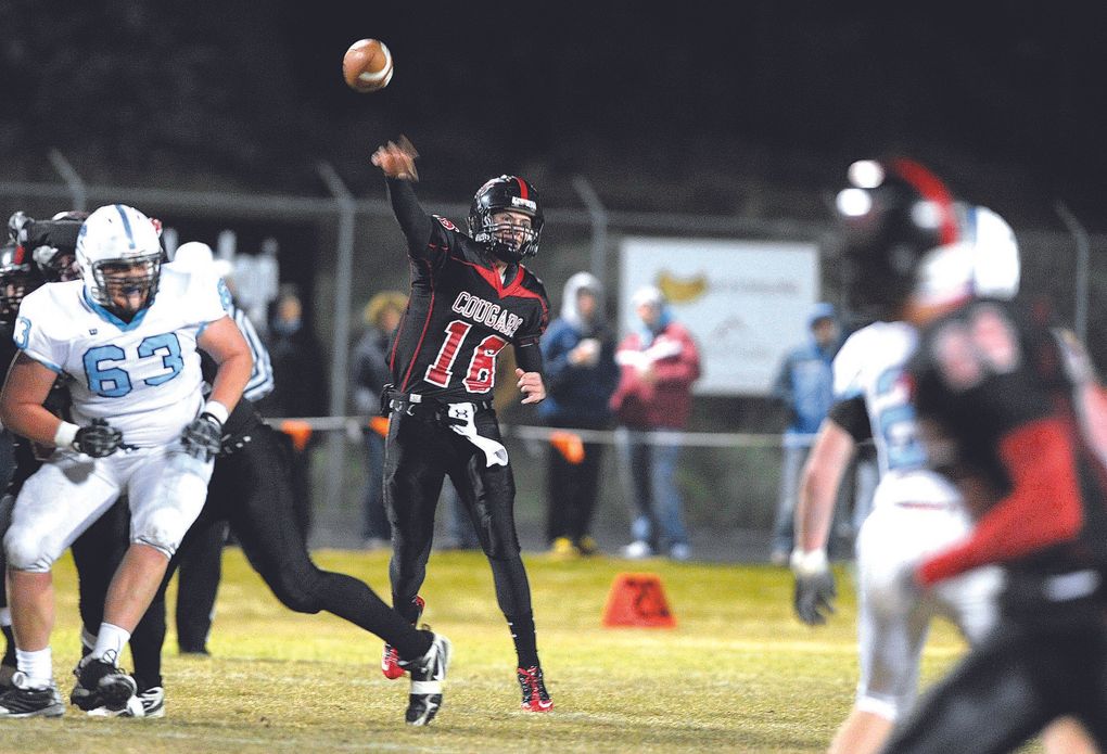 Jacob Hollister drops back and throws a pass for a completion during a high school football game. (Ryan Brennecke / The Bulletin)