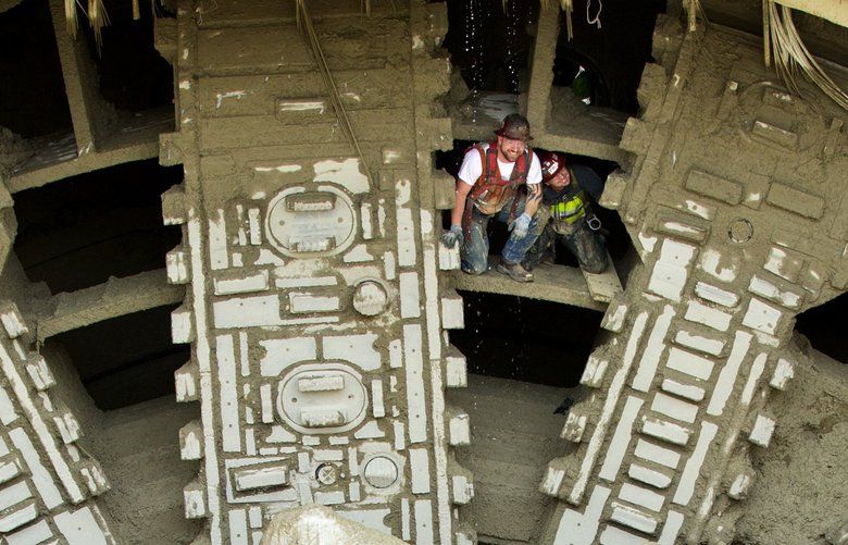 Tunneling crew members including Jake Chopic, left, with Seattle Tunnel Partners, emerges from the cutter head after the giant tunneling machine Bertha broke into daylight as the giant drill chewed through the side of the disassembly vault and broke through the north portal wall on Tuesday April 4th, 2017 after nearly four years of boring underneath downtown Seattle. 201434