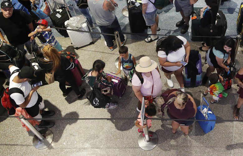 More families says they are finding out at the airline check-in counter that they are not seated with their children. Shown here are people waiting to check in at McCarran International Airport in Las Vegas in 2018. (John Locher / Associated Press, File)