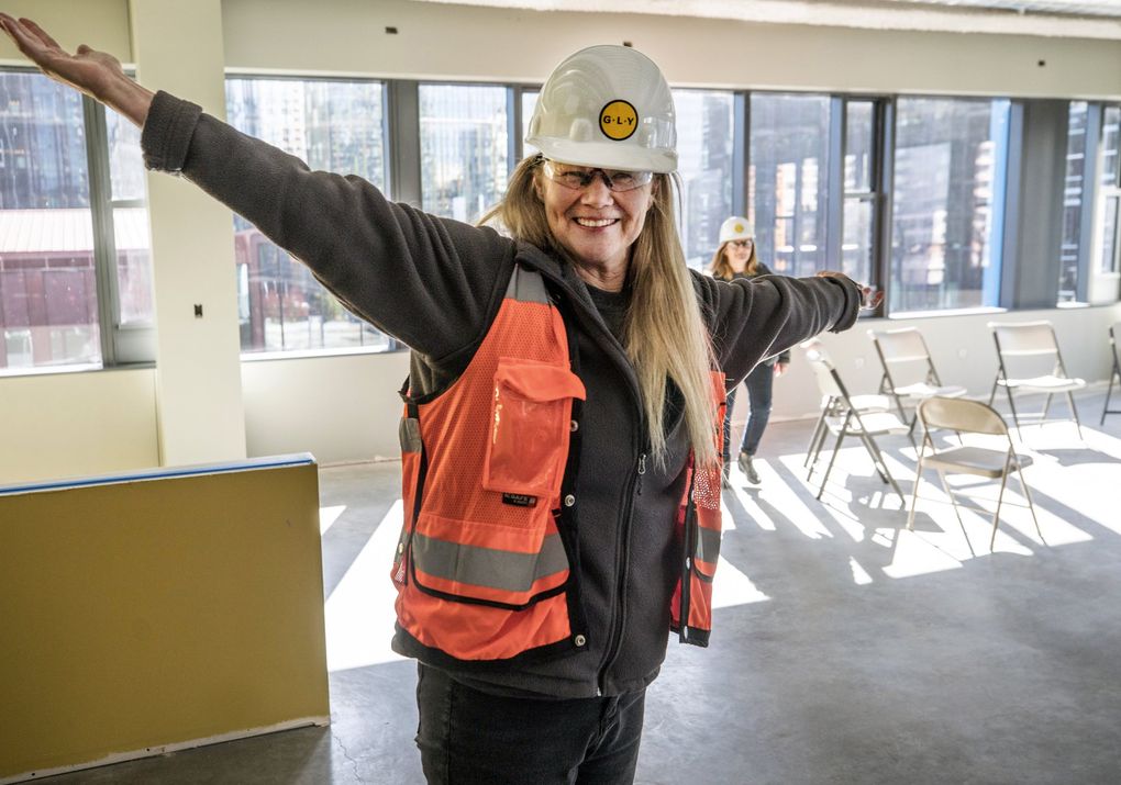 Marty Hartman, executive director of Mary’s Place can’t contain her joy as she walks into the “kids club” room at a new family shelter scheduled to open in an Amazon building this year. (Steve Ringman / The Seattle Times)