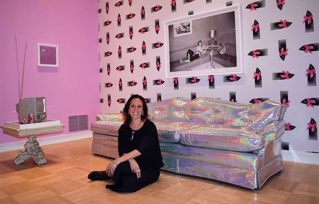 Shamim M. Momin, senior curator at Henry Art Gallery, seated in an installation by Sadie Barnette. (Courtesy of Henry Art Gallery)