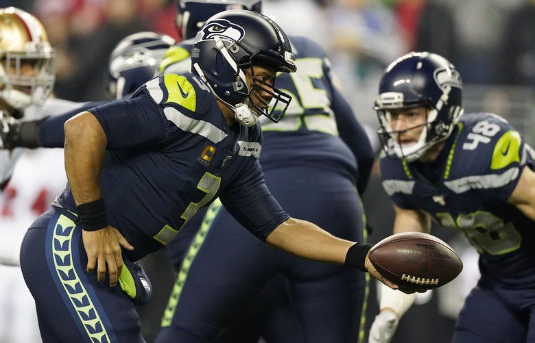 Seattle Seahawks quarterback Russell Wilson (3) looks to hand off under pressure from the 49ers defense during the opening drive in the first quarter, which ended with a punt, as the Seahawks play the San Francisco 49ers Sunday, December 29, 2019 at CenturyLink Field in Seattle. 212507