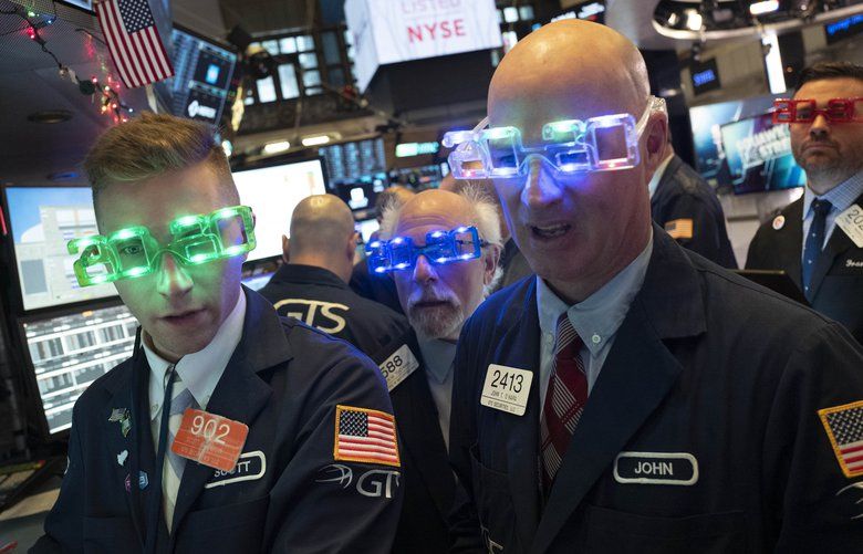Stock traders wear New Year’s 2020 party glasses at New York Stock Exchange, Tuesday, Dec. 31, 2019. Stocks slipped globally in quiet New Year’s Eve trading Tuesday with many markets closed. Wall Street could close 2019 with back-to-back daily losses in a year that the U.S. posted the largest market gains since 2013. (AP Photo/Mark Lennihan) NYML105 NYML105