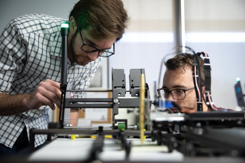 Engineers Michael Davis, left, and Justin Seganti work a printing machine on Nov. 5 at Handwrytten. (Photo for The Washington Post by Davis Winborne).