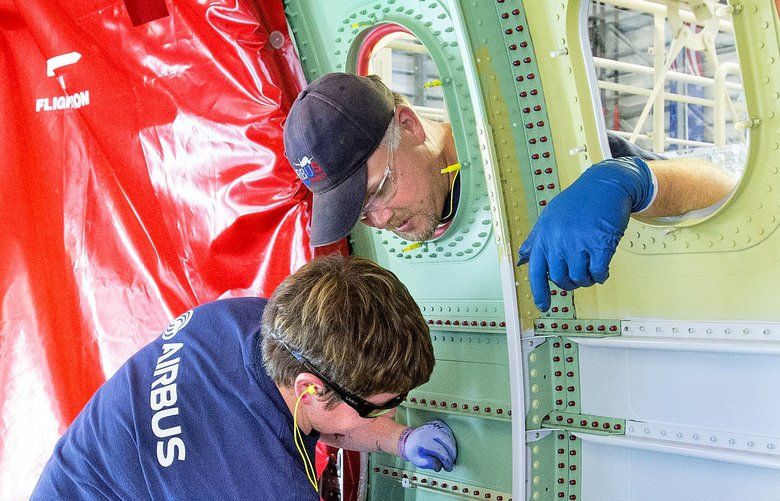 Richard Ward, an Airbus structural mechanic, (outside airplane), and Jennifer Mulligan assemble a section of fuselage at a new production facility in Mobile Alabama. The  facility will eventually roll out 4 airplanes each month.