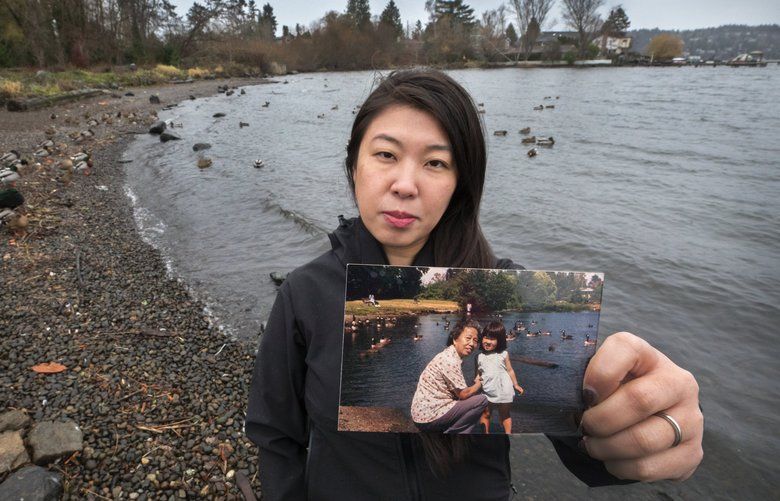 Thursday, January 1, 2019.    Rainier Beach resident Sally Li stands on the same stretch of Rainier Beach reflected in the photo of her and her grandmother when she was little.  For the past three years community advocates have been working to get Be’er Sheva Park and the beach renovated.   212514