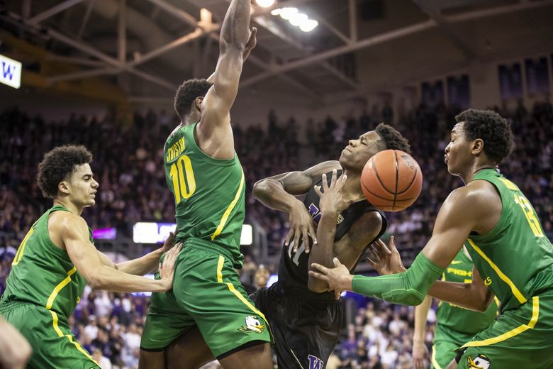 Oregon’s Shakur Juiston picks up his 5th foul in overtime against Washington’s Nahziah Carter, forcing him from the game. (Dean Rutz / The Seattle Times)