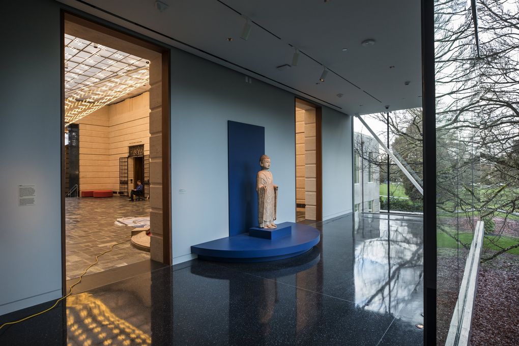 The Chinese marble sculpture “Standing Buddha,” dating to the sixth century, is positioned at the divide between Seattle Asian Art Museum’s old 1933 building and its new, glassy addition. (Steve Ringman / The Seattle Times)
