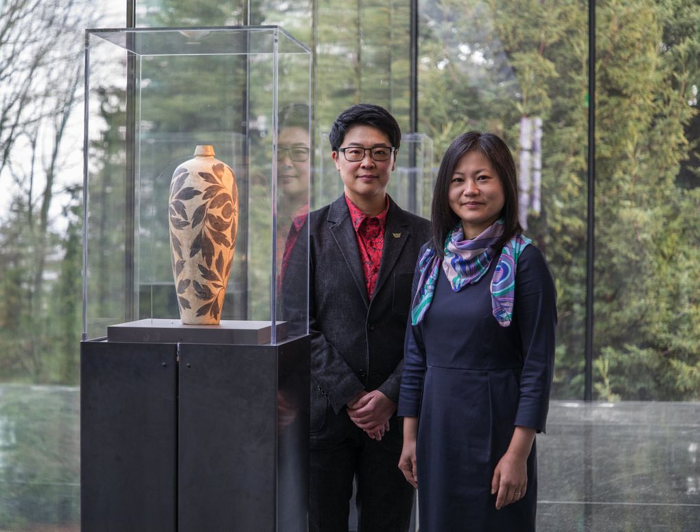 Curators Ping Foong and Xiaojin Wu stand in the new, glassed-in terrace at the renovated Seattle Asian Art Museum. (Steve Ringman / The Seattle Times)