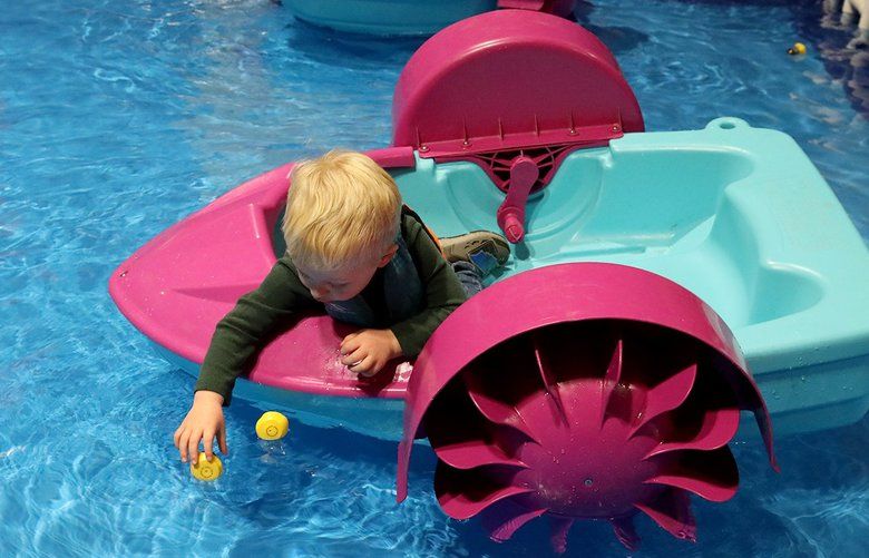 James Croxall, 3, foreground, and his older brother, Jonathan, 5, play at the indoor pool at the Seattle Boat Show, which closes Saturday. James seems particularly interested in the rubber duckies. (Greg Gilbert / The Seattle Times)