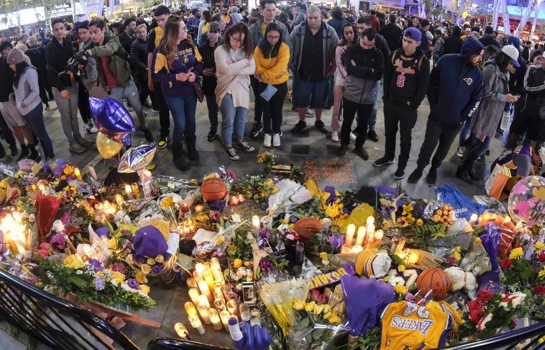 People gather at a memorial for Kobe Bryant near Staples Center Monday, Jan. 27, 2020, in Los Angeles. Bryant, the 18-time NBA All-Star who won five championships and became one of the greatest basketball players of his generation during a 20-year career with the Los Angeles Lakers, died in a helicopter crash Sunday. (AP Photo/Ringo H.W. Chiu) NYOTK NYOTK