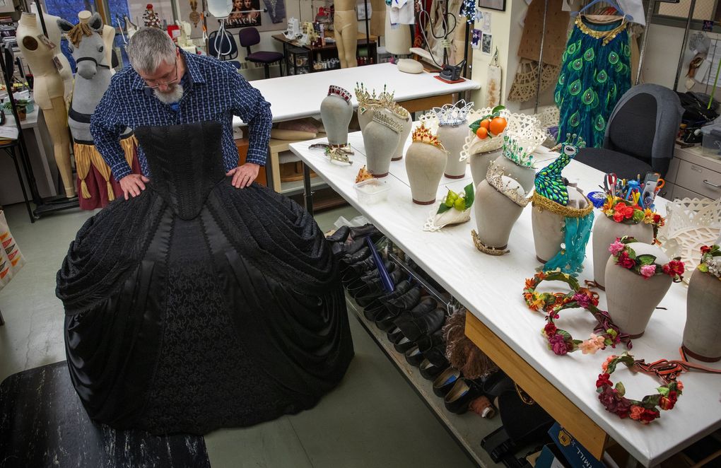 Terry Frank, longtime Pacific Northwest Ballet craftsperson, is retiring after a long career with PNB. He’s shown standing behind a dress with some of his tiaras resting to his side. (Ellen M. Banner / The Seattle Times)